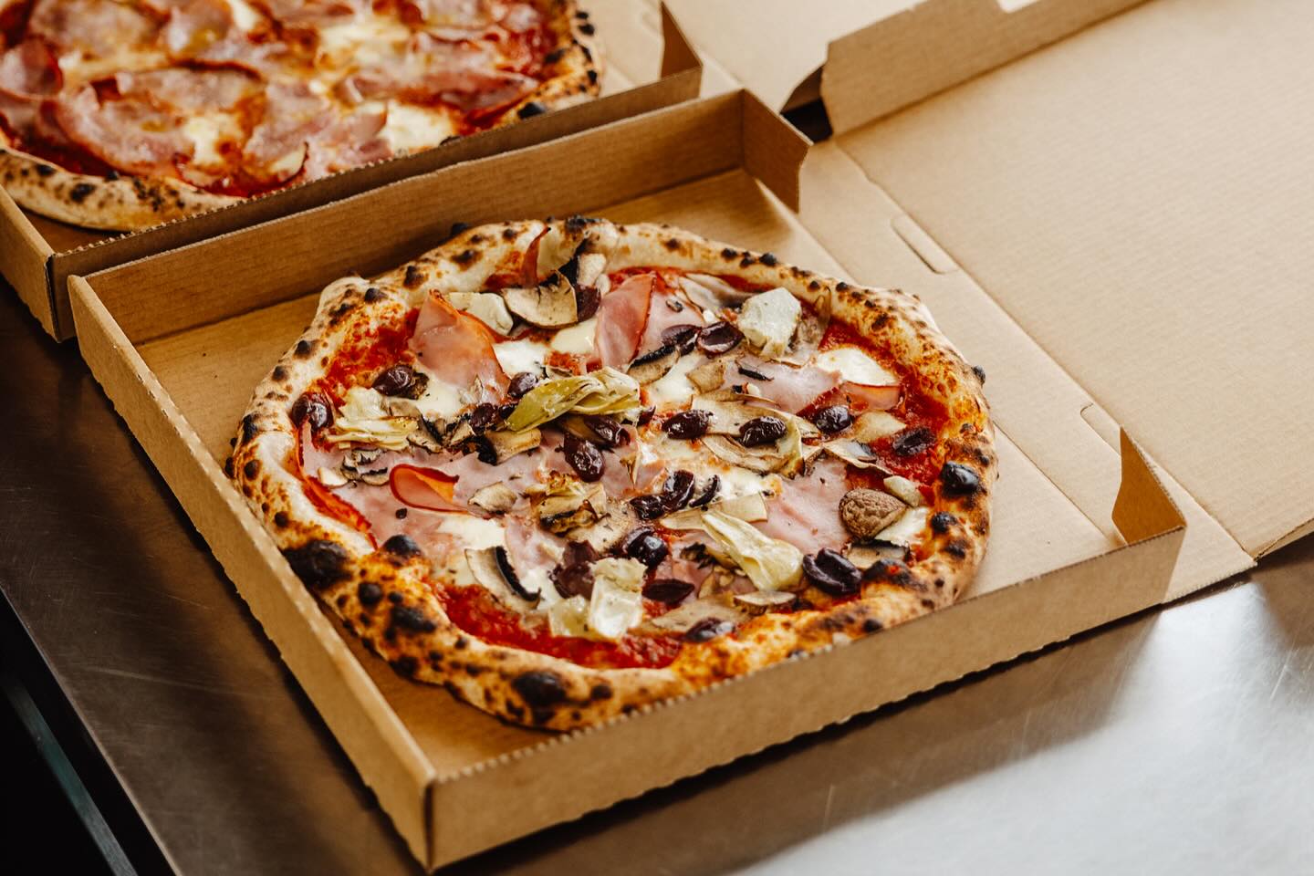 Woodfired pizza with ham, mushrooms and olives